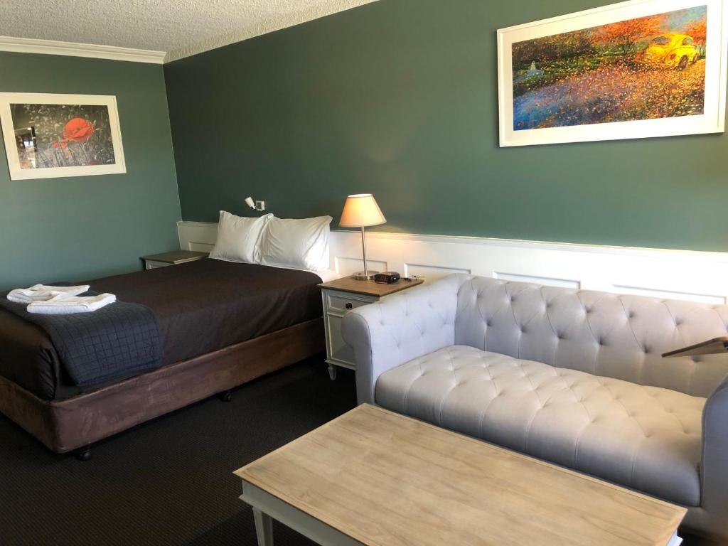 a hotel room with a bed and a couch at Dog Rock Motel in Albany