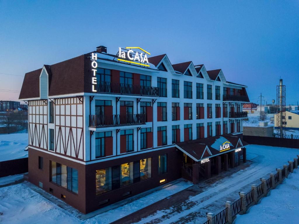 un grand bâtiment avec un panneau en haut dans l'établissement LaCasa Hotel, à Karaganda