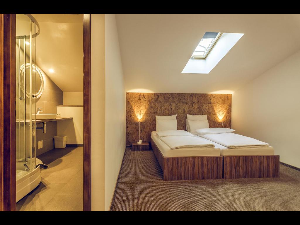 ein Schlafzimmer mit einem Bett und ein Badezimmer mit einer Dusche in der Unterkunft Pensiunea Oscar in Câmpina