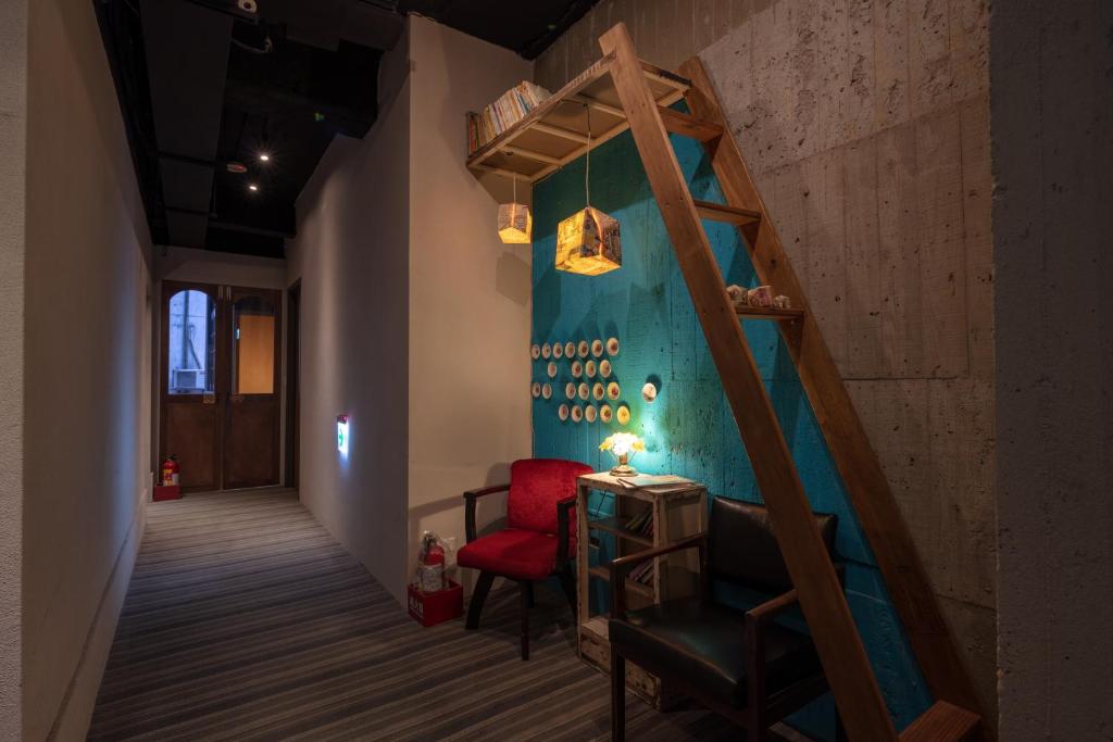 a room with a staircase and a red chair at Cho Hotel in Taipei