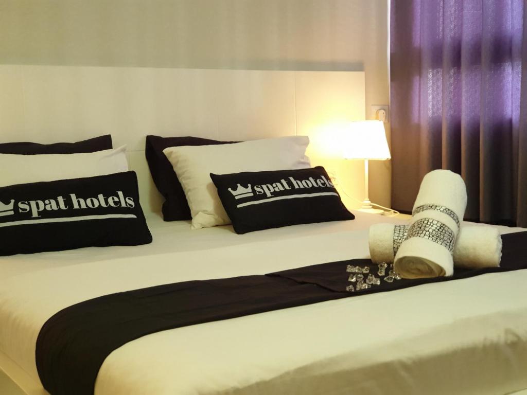 a bed with black and white pillows on it at Spat Hotel Ashdod in Ashdod