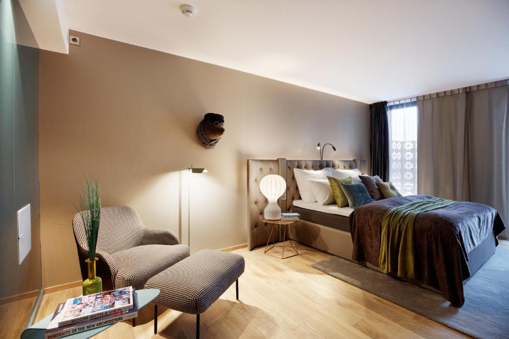 a bedroom with a bed, chair, and a lamp at Clarion Hotel The Hub in Oslo