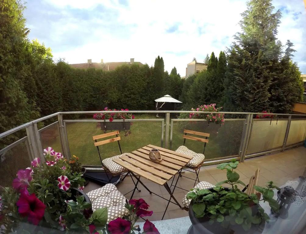 einen Holztisch und Stühle auf einem Balkon mit Blumen in der Unterkunft Apartmán s terasou in Olomouc