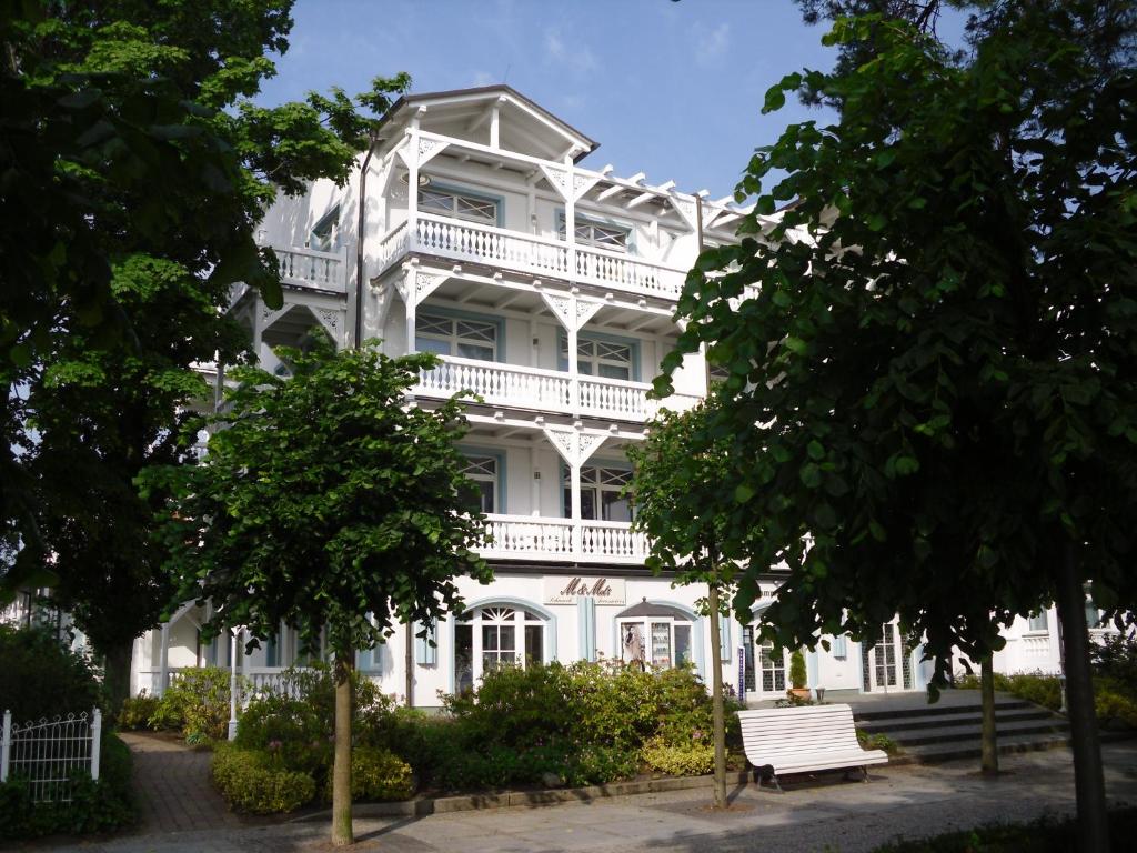 un bâtiment blanc avec un banc devant lui dans l'établissement Villa Strandburg, à Binz