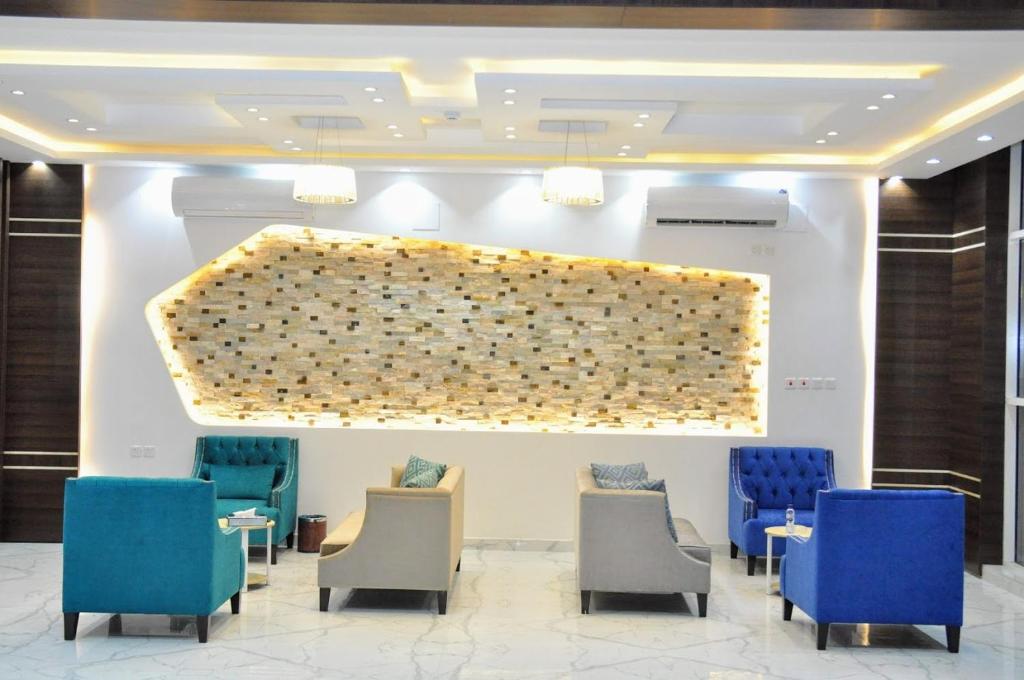 a waiting room with chairs and a large wall at منازل بلقيس للشقق المخدومة فرع الشفاء in Hail