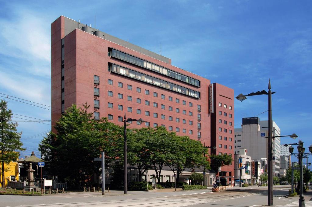 a large red brick building on a city street at Toyama Manten Hotel in Toyama