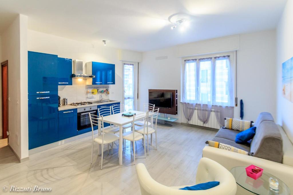 een keuken en een woonkamer met blauwe kasten en een bank bij appartamento ristrutturato a nuovo !!! in Varazze