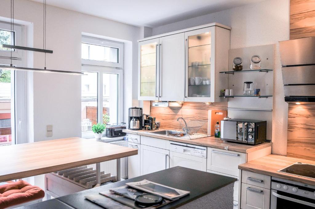 a kitchen with white cabinets and a wooden counter top at Tarata Haus in Halle an der Saale