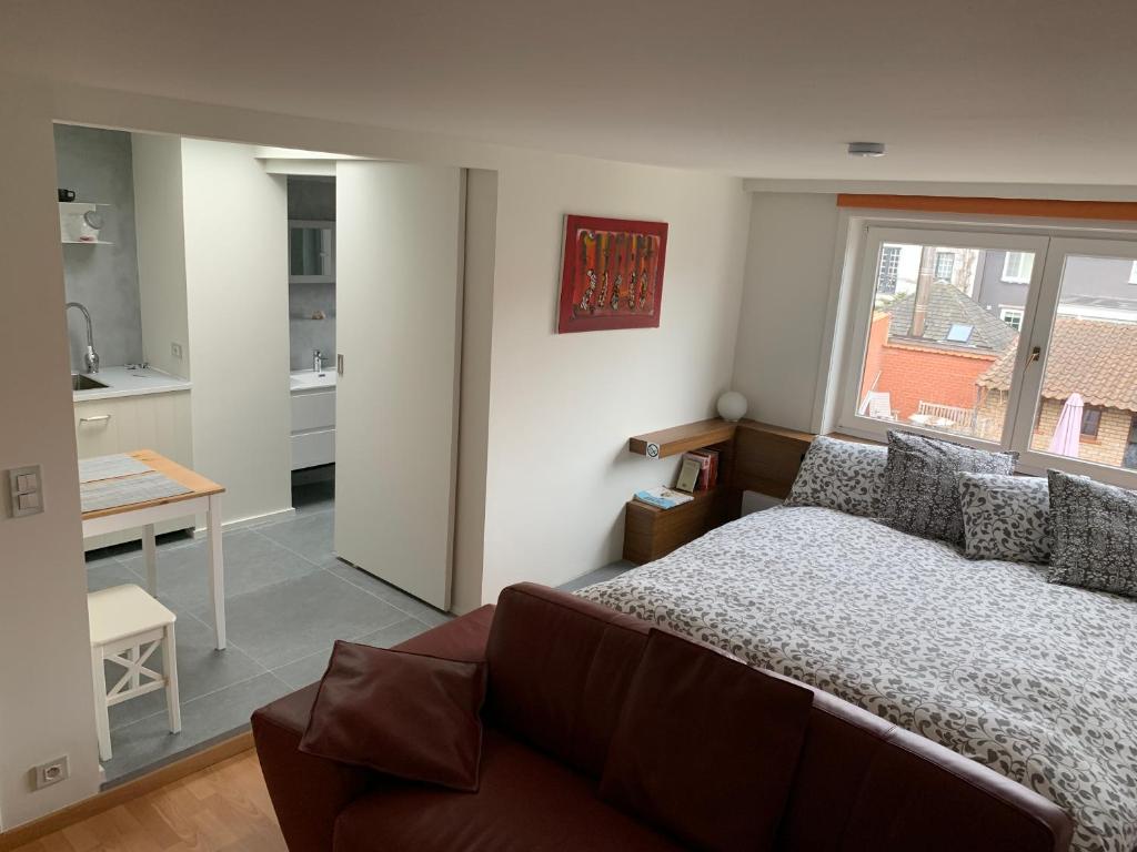 um quarto com uma cama, uma mesa e uma cozinha em SleutelVan8 em Knokke-Heist