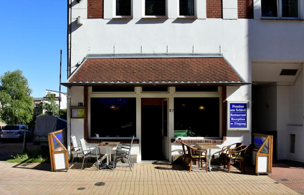 ein Restaurant mit Tischen und Stühlen vor einem Gebäude in der Unterkunft Pension am Schloss in Schwerin