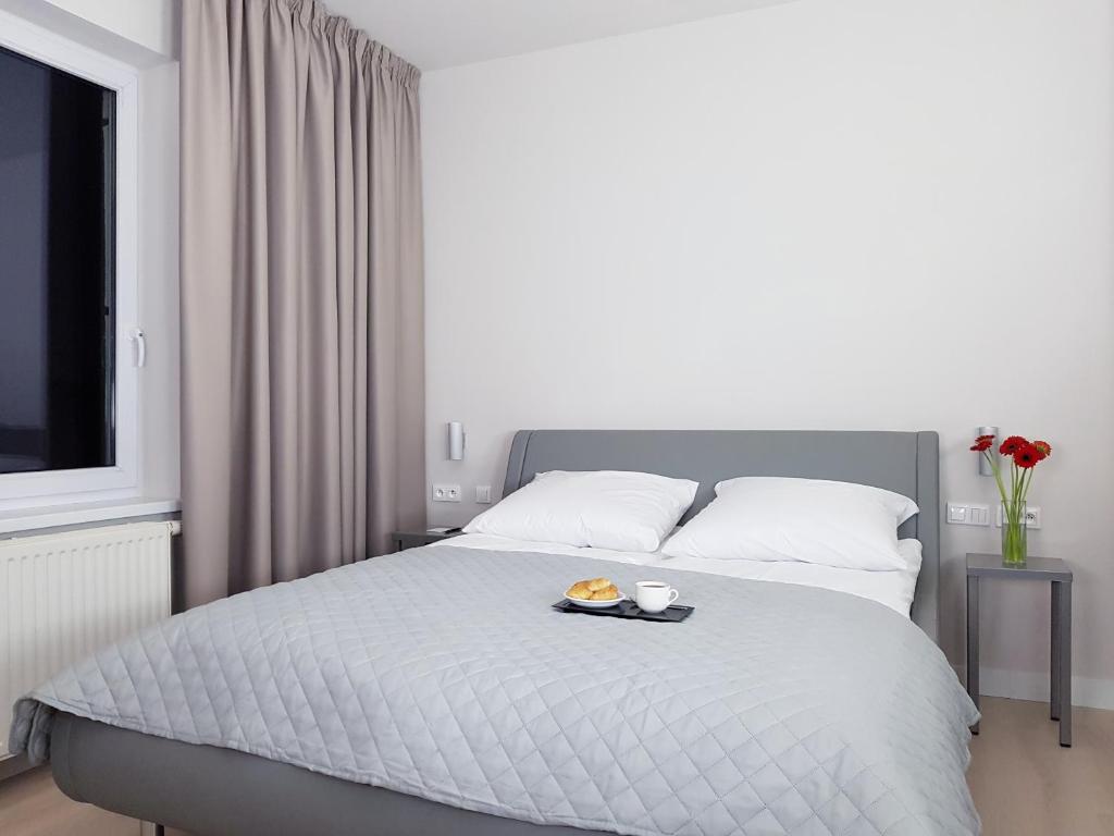 a bedroom with a bed with a tray of food on it at Chopin Apartments - Eco in Warsaw