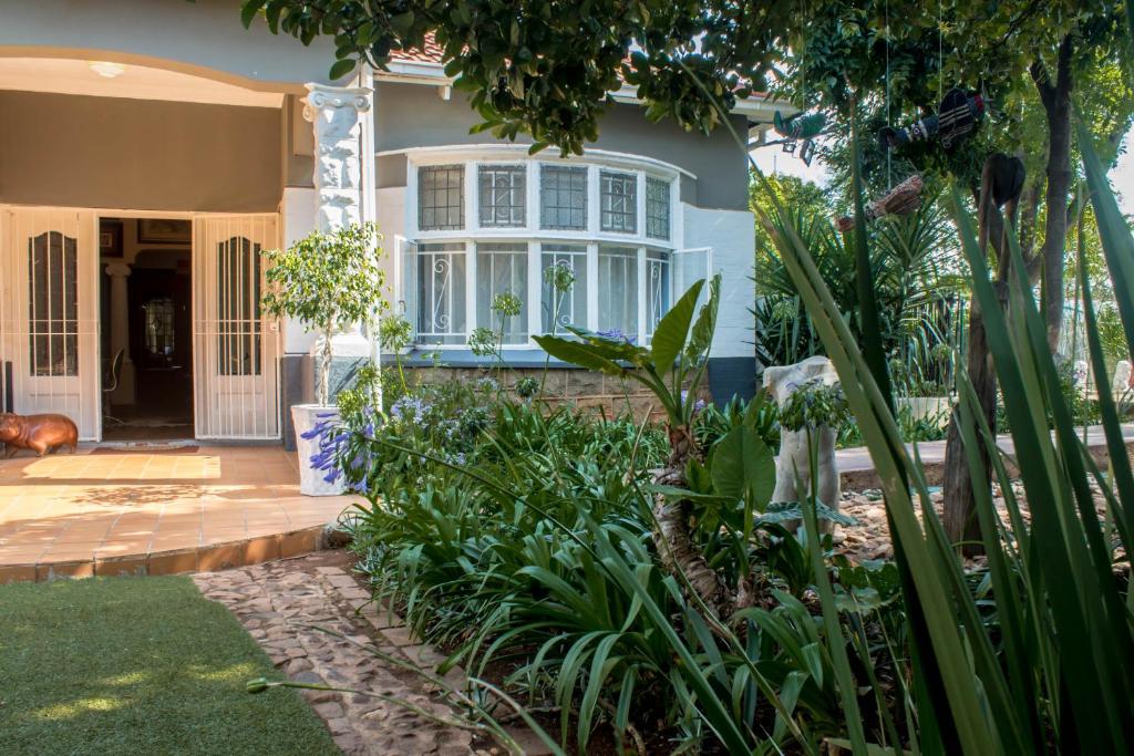 een huis met een tuin met planten ervoor bij Sunbury Bed and Breakfast in Johannesburg