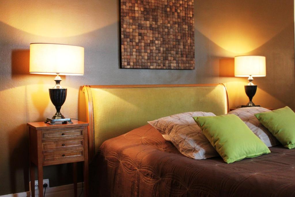 杜埃的住宿－拉帕特杜艾雷絲住宿加早餐旅館，一间卧室配有一张带两盏灯的床。