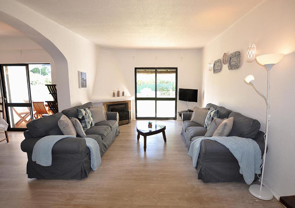 un grand salon avec des canapés et une cheminée dans l'établissement E&M Beach House Aldeamento do Levante III, à Porches