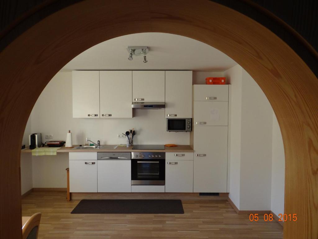 un arco en una cocina con armarios blancos en Ferienwohnungen Resch, en Eckberg