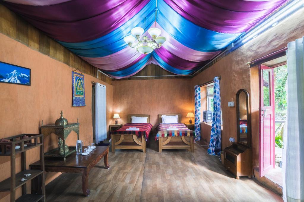 een kamer met 2 bedden en een kleurrijk plafond bij Yangsum Heritage Farm in Rinchingpong