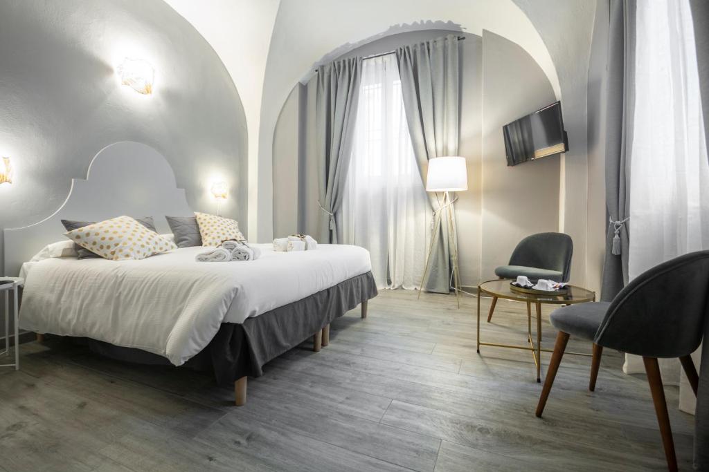 a bedroom with a large bed and a chair at La Lu cozy rooms in Pisa