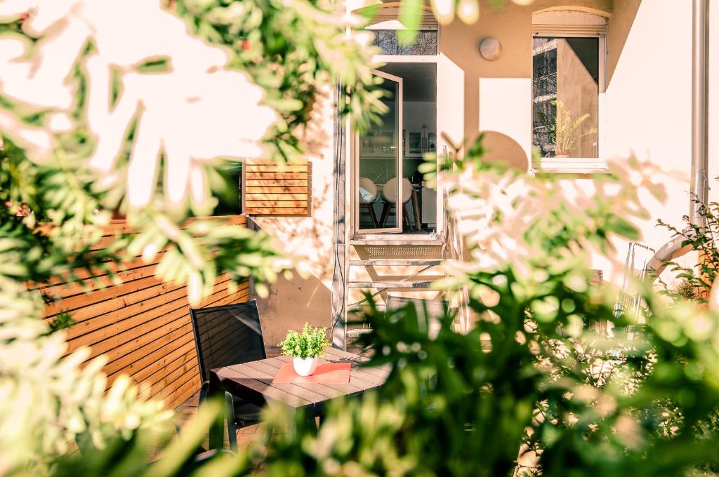 une terrasse avec une table en bois et des plantes en pot dans l'établissement Tarata Wohnung, à Halle-sur-Saale