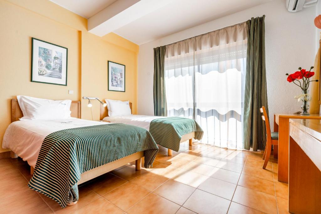 アルトゥーラにあるAltura Inn Beachのベッド2台と窓が備わるホテルルームです。