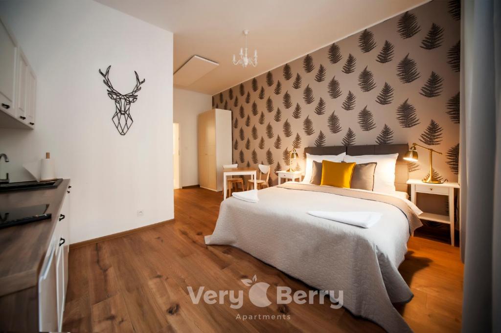 een slaapkamer met een groot bed en een muur met bladeren erop bij Very Berry - Sniadeckich 1 - Fair Trade Apartments, check in 24h in Poznań