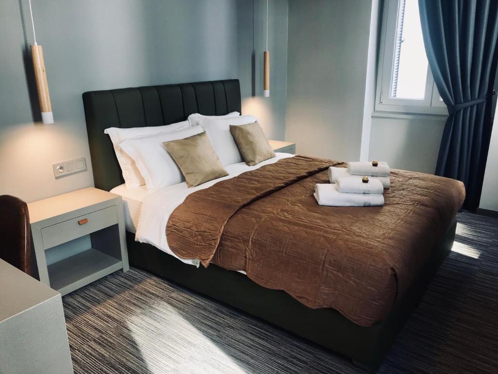 sypialnia z dużym łóżkiem i dwoma ręcznikami na nim w obiekcie Metis Athens Suites w Atenach
