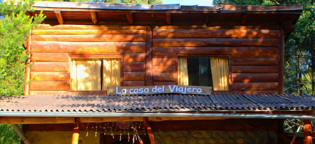 una cabaña de madera con un cartel que lee el viejo vancouver de la muchacha en La Casa del Viajero Hostel en El Bolsón