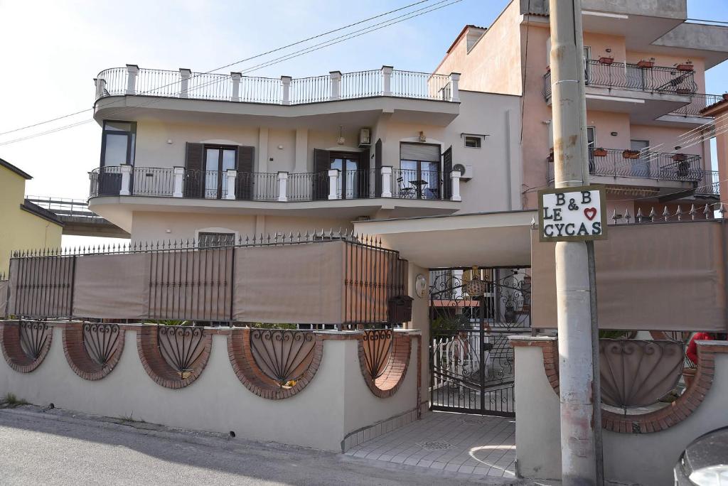 un edificio con balconi e un cartello stradale su un palo di B&b Le Cycas a Castellammare di Stabia