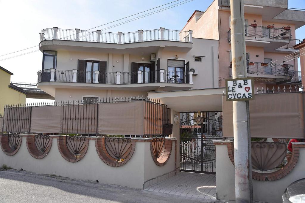 a building with balconies and a street sign on a pole at B&b Le Cycas in Castellammare di Stabia