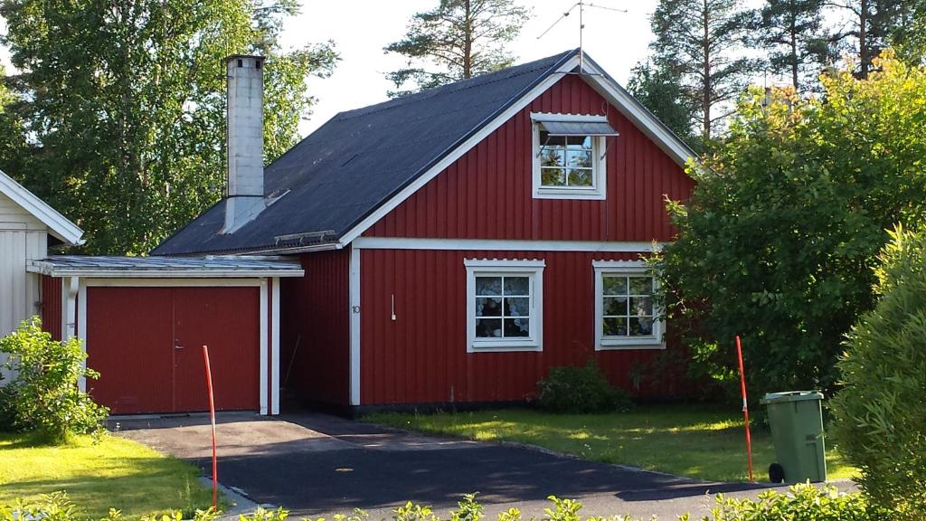 een rood huis met een zwart dak bij Villa Elsy in Vidsel