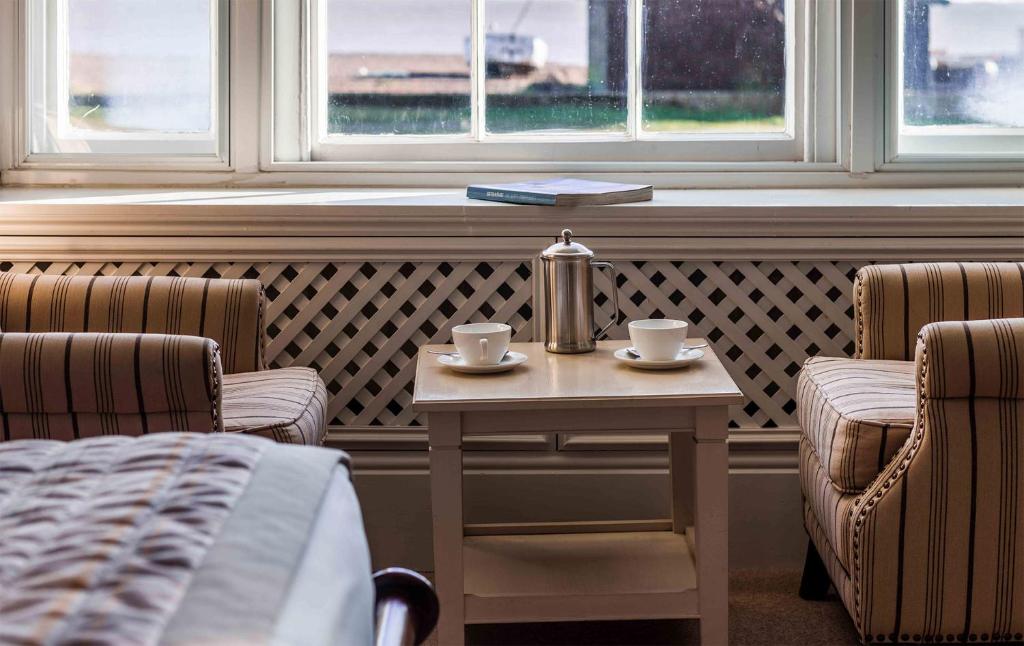 a room with two chairs and a table with two cups at The White Lion Hotel in Aldeburgh