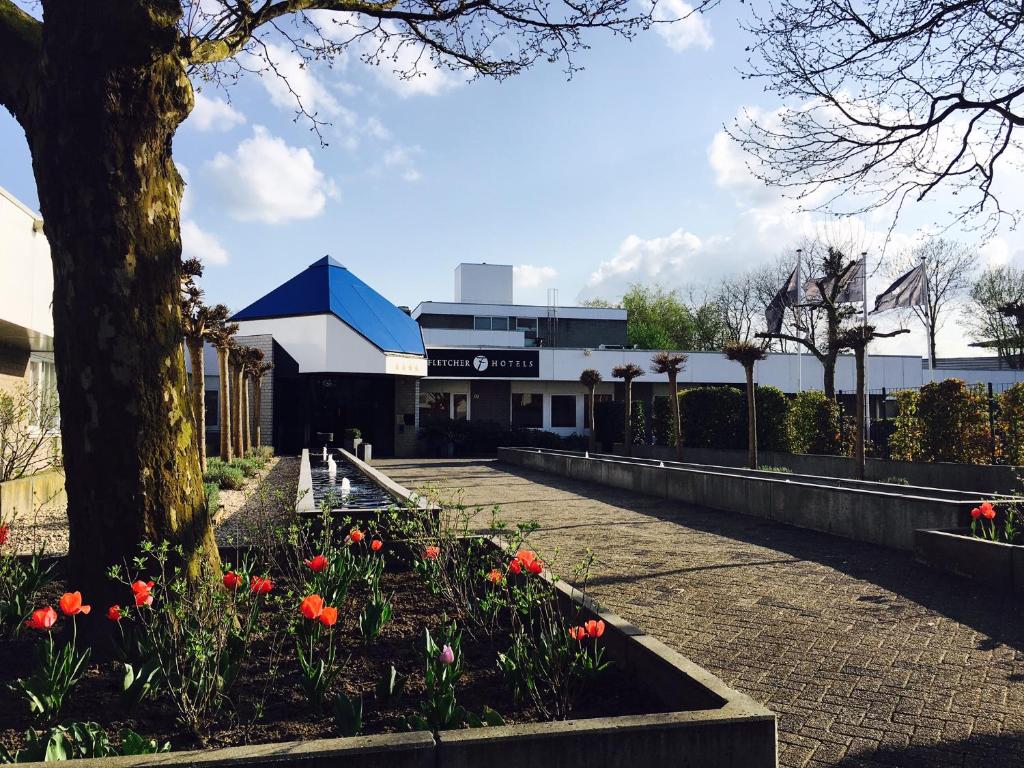 un edificio con muchas flores en un jardín en Fletcher Resort-Hotel Zutphen en Zutphen