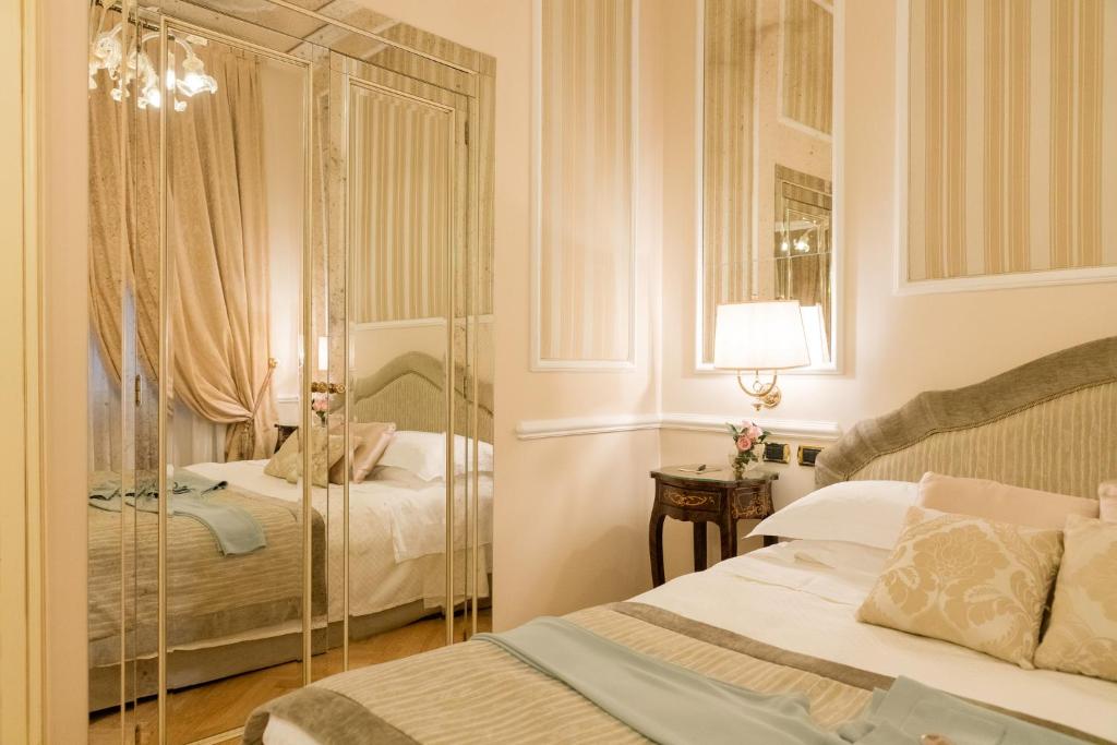 a bedroom with a bed and a mirror at Grand Hotel Majestic gia' Baglioni in Bologna