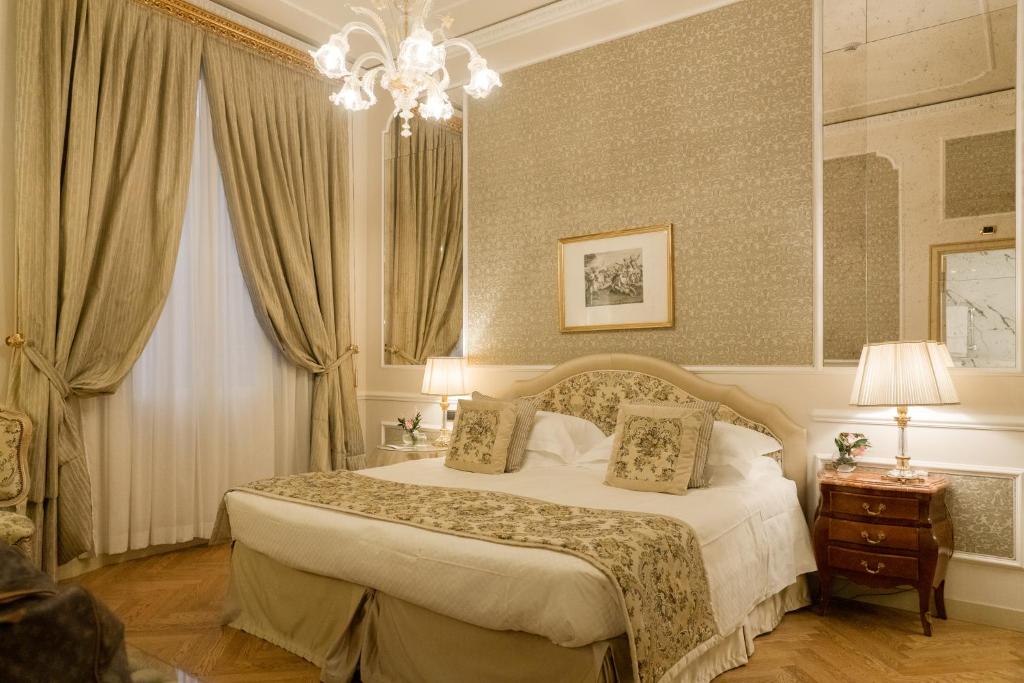 a bedroom with a bed and a chandelier at Grand Hotel Majestic gia' Baglioni in Bologna