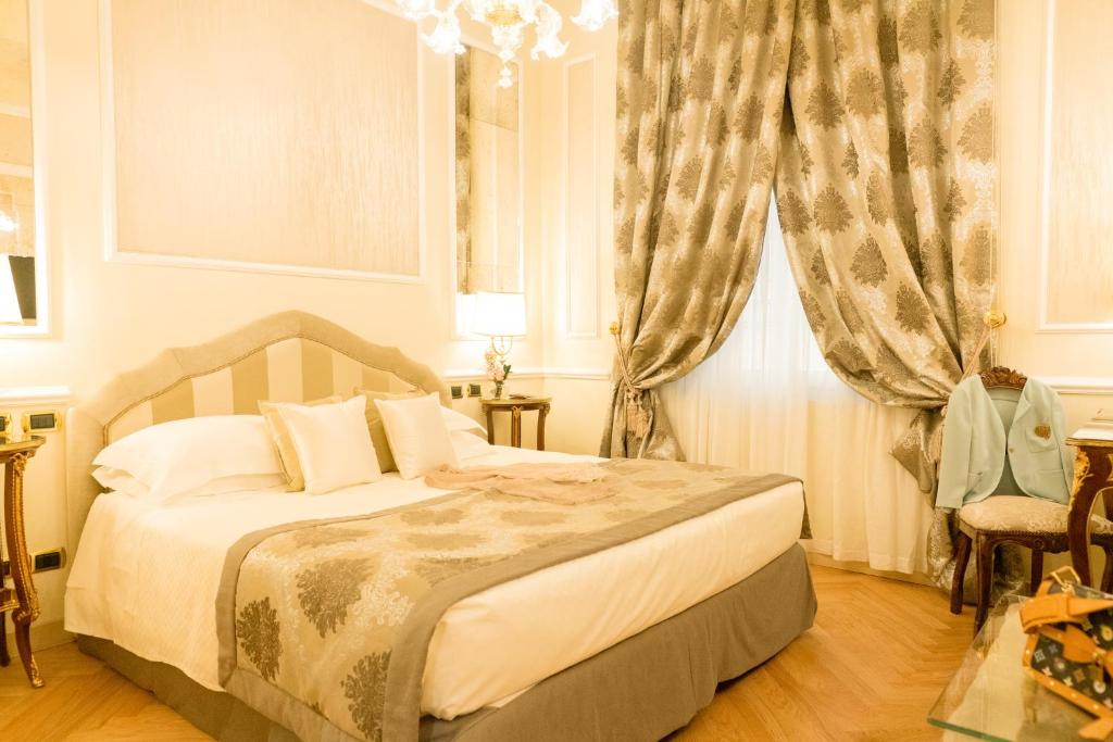 a bedroom with a bed and a window with curtains at Grand Hotel Majestic gia' Baglioni in Bologna