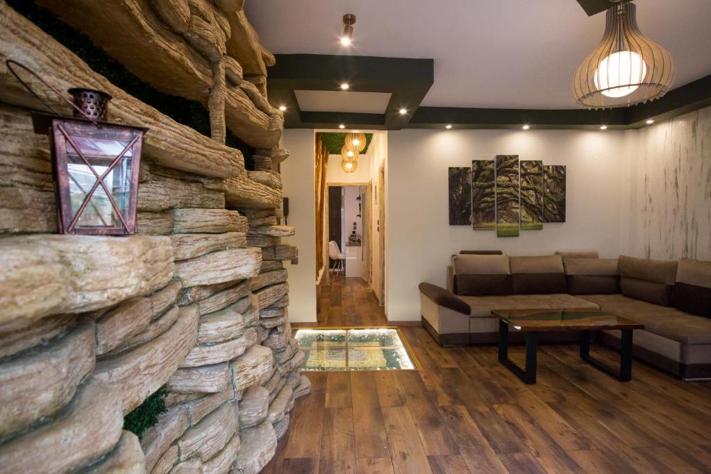 a living room with a large stone wall at Thess Nature Apartment in Thessaloniki
