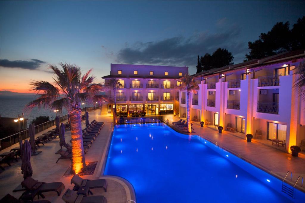 a hotel with a swimming pool in front of a building at Neopol Hotel in Kuşadası