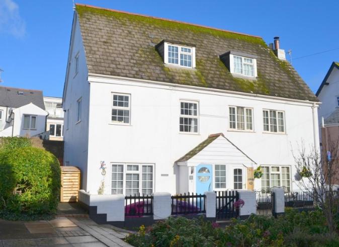a white house with a green roof at Justa Cottage in Shaldon