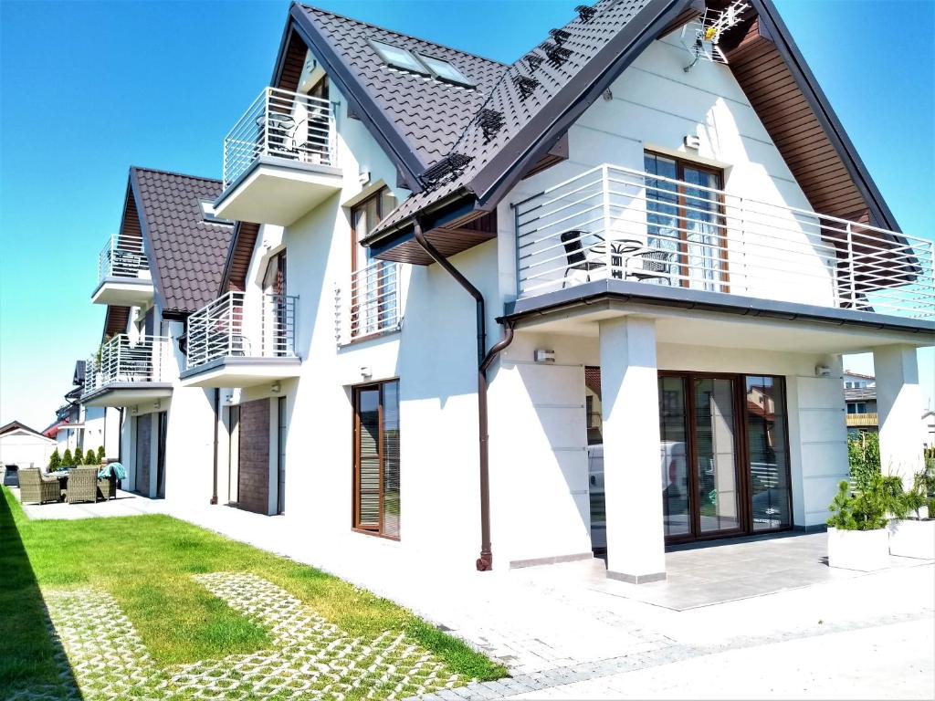 a white house with a black roof at Willa Trawers in Władysławowo