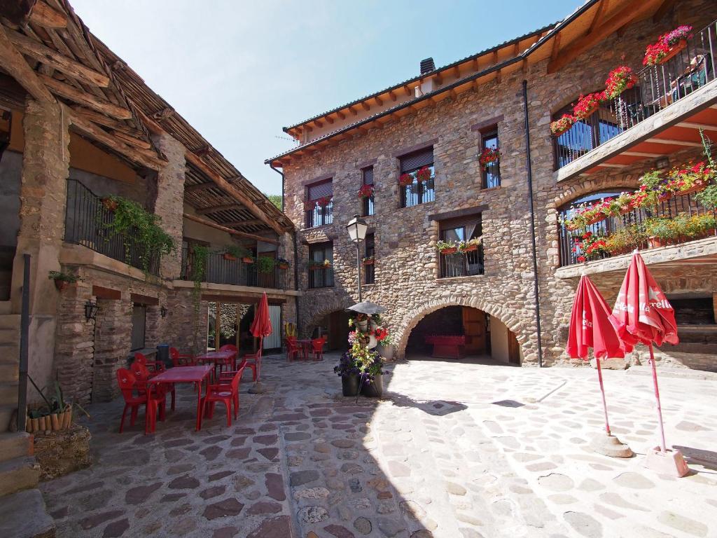 an outdoor patio with tables and umbrellas in a building at Casa Batlle in Les Iglésies