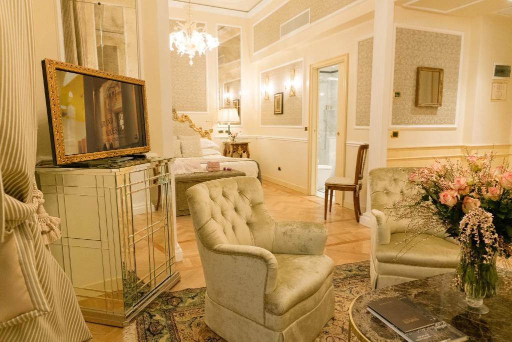 a living room with two chairs and a television at Grand Hotel Majestic gia' Baglioni in Bologna