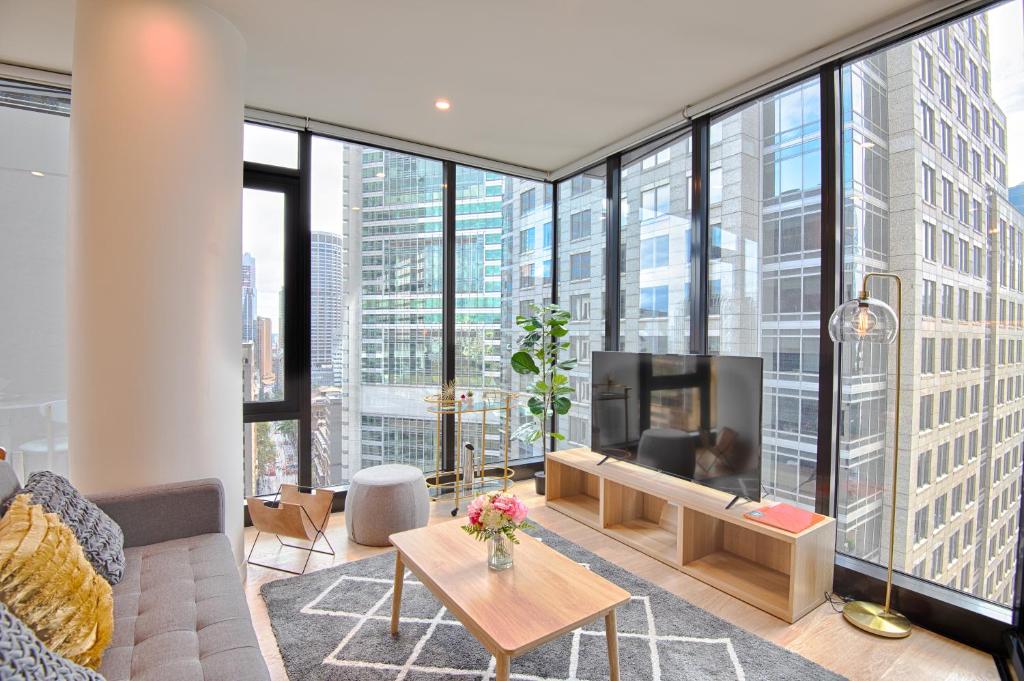 a living room with a tv and large windows at MetaWise Sydney CBD Luxury City view 2BED Apartment in Sydney