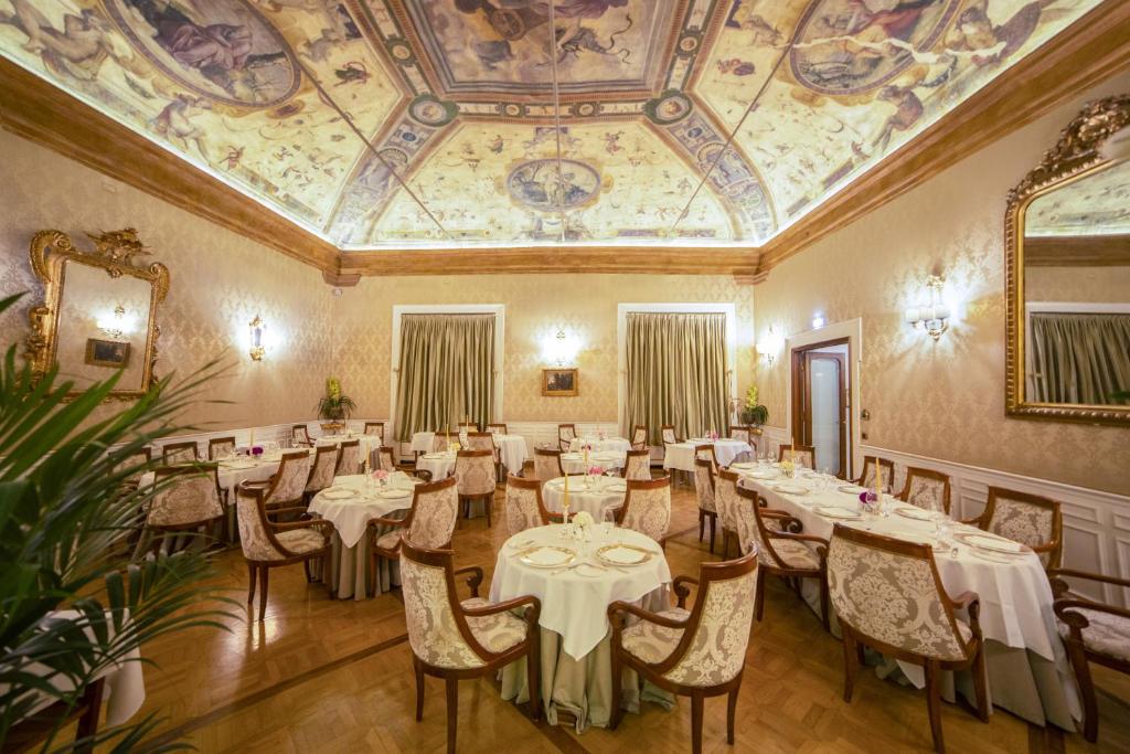 a dining room with tables and chairs and a ceiling at Grand Hotel Majestic gia' Baglioni in Bologna