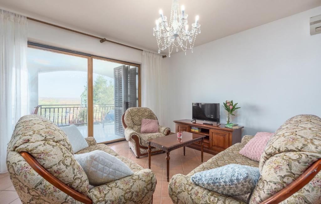 a living room with chairs and a couch and a tv at Apartmani Katalin in Mušalež