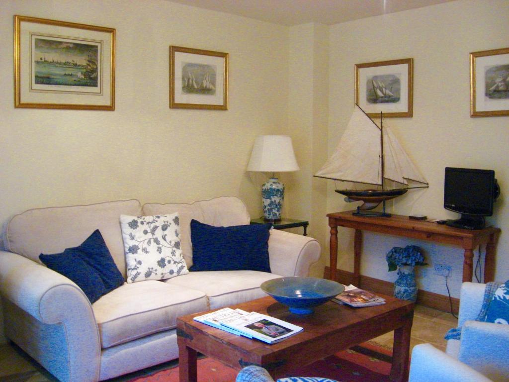 a living room with a white couch and a table at Oundle Bespoke Apartments in Oundle