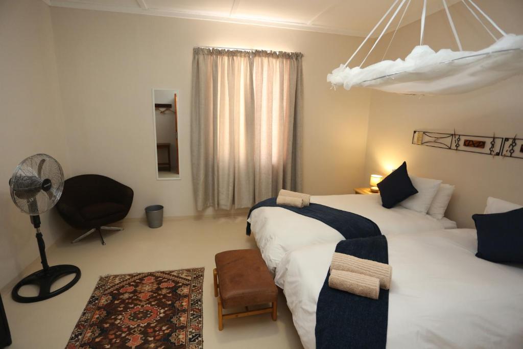 ein Hotelzimmer mit 2 Betten und einem Ventilator in der Unterkunft Aloe Rock House in Aus