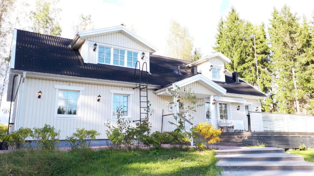 a white house with a black roof at Expe Finland in Porvoo