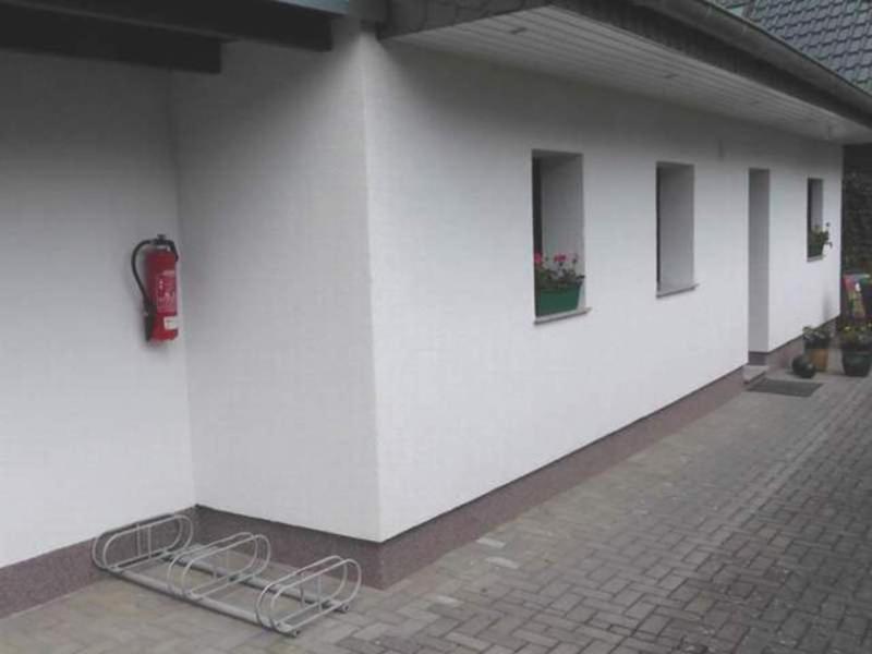 
a building with a red door and a white wall at Ferienhaus am Hain Naturschutzgebi in Eldena
