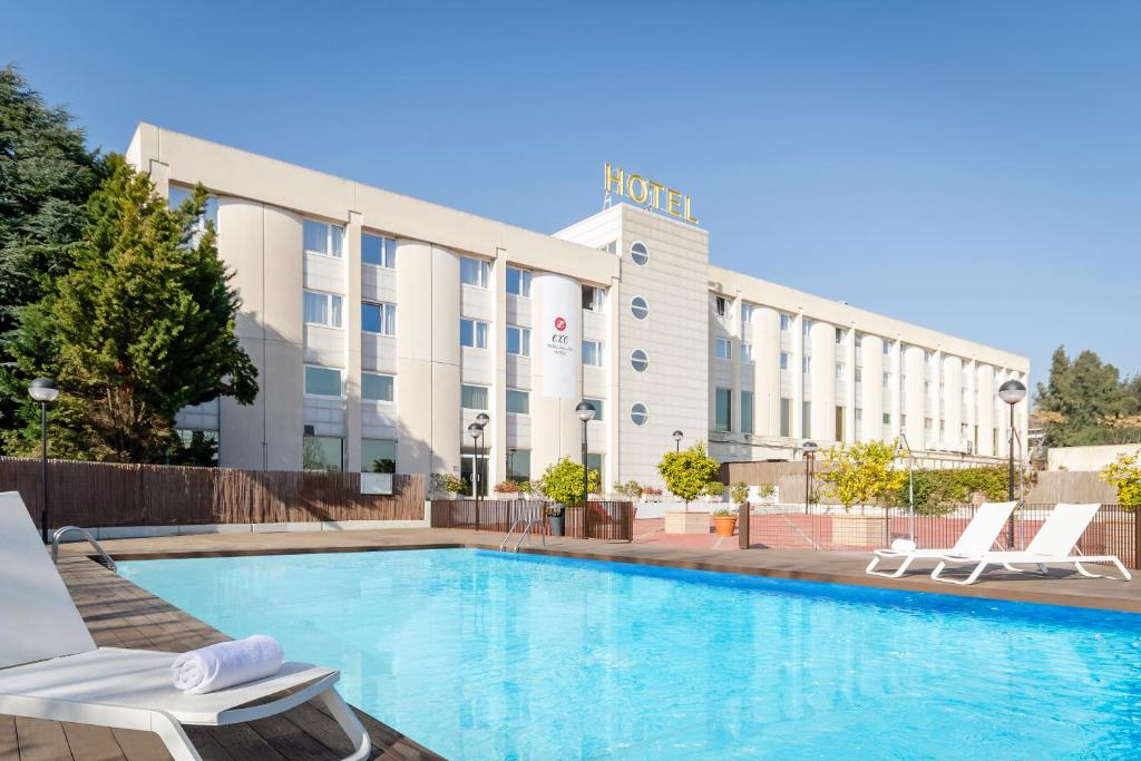 una piscina de hotel con sillas y un hotel en Exe Parc del Vallés, en Cerdanyola del Vallès