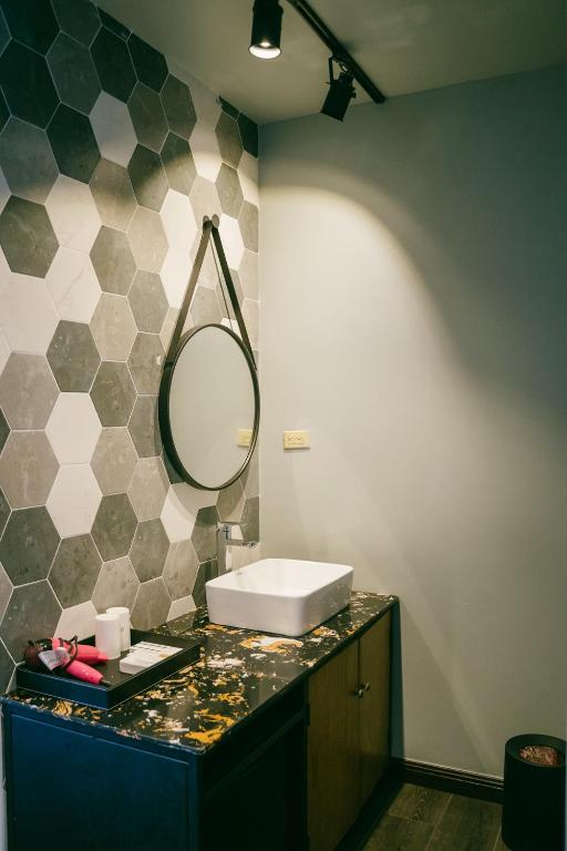 a bathroom with a sink and a mirror on a counter at Saipan Skyline Designers Hotel in Saipan