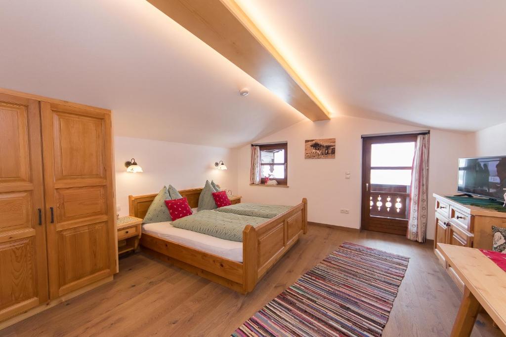a bedroom with a bed and a television in a room at Hagerhof in Walchsee